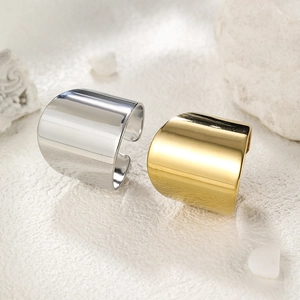 Polished 14k gold and silver stainless steel open rings displayed on a stone surface