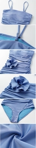 Detail of light blue swimsuit featuring 3D floral decoration and metallic textured fabric
