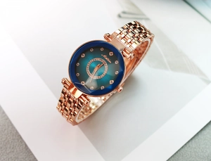 Détail d'une montre femme or rose avec cadran bleu foncé et index en strass
