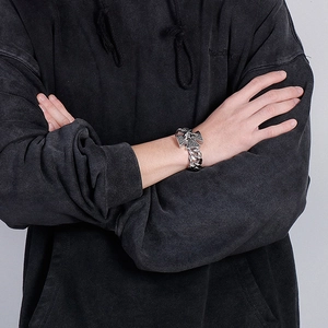 Detail of masculine stainless steel bracelet with vintage cross charms and Cuban links