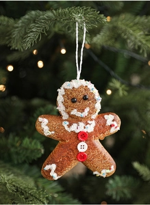 Detail of gingerbread man Christmas tree ornament with white icing and festive decor