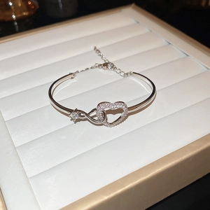 Detail of silver heart and infinity symbol bracelet with white sparkling zircons