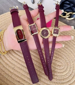 Close-up of elegant burgundy leather strap watches with gold cases for women