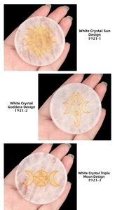 Macro detail of white crystal energy stones with gold sun, goddess, and moon symbols