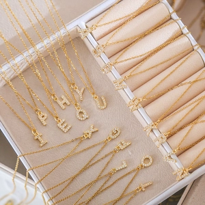 Gold square alphabet necklace with cubic zirconia paving in a jewelry display box
