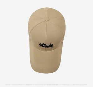 Top view of khaki cotton baseball cap featuring black cursive embroidery and long brim