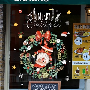 Christmas wreath and Santa window stickers with Merry Christmas greeting on glass window