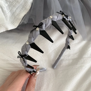 Detail of grey and black rhinestone bow headband with built-in hair clips for styling
