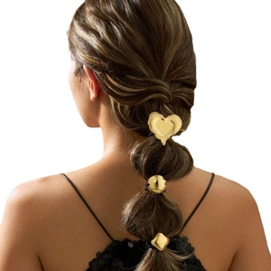 Golden metal hair accessories set with heart, circle and diamond shapes on a bubble ponytail
