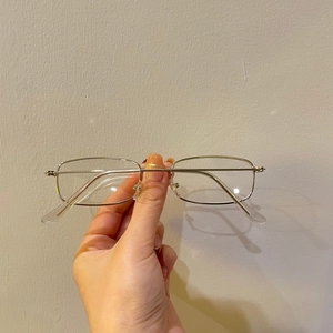 Detailed close-up of a silver thin metal square frame sunglasses with transparent tips
