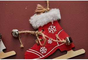 Macro shot of red wooden ice skate ornament with white snowflakes and metal bells