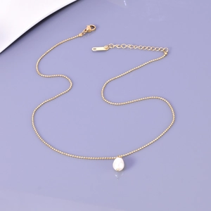 Detailed shot of a single pearl on a gold bead chain with lobster clasp and extender