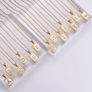 Detailed display of 18k gold plated square initial necklaces with white shell inlay