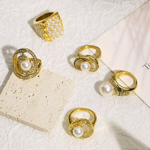 Detailed close-up of gold-plated rings with pearls and sparkling micro-inlaid zircon