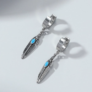 Detail of vintage feather drop earrings with turquoise stone in polished silver steel