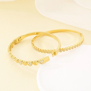 Elegant gold-plated stainless steel heart bangle featuring sparkling white rhinestones