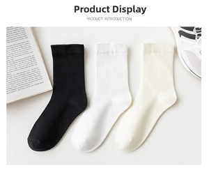 Detailed view of three-pack cotton crew socks in black, white and cream with ribbed cuffs