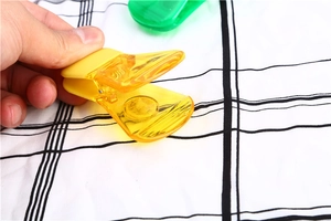 Dettaglio della clip sigillante in plastica gialla trasparente con molla in metallo