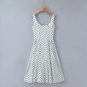 Détail du col carré et des larges bretelles d'une robe blanche à pois rétro chic