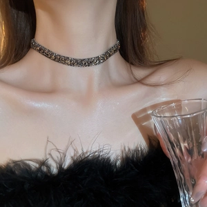 Close-up of elegant collar necklace with dark crystals on a model for a luxury look