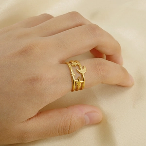 Nahaufnahme eines goldenen Edelstahlrings mit Mond und Sternen am Finger