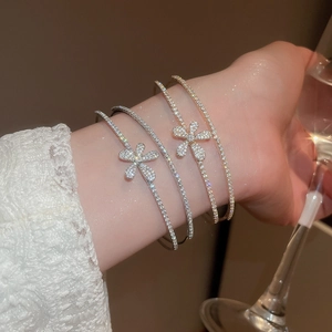 Close-up of double-layer zircon flower bangles in silver and gold on model's wrist