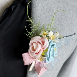 Pink and blue artificial rose boutonniere for groom on a gray suit wedding jacket