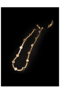 Close-up of golden flat snake chain choker with polished circular discs on black background