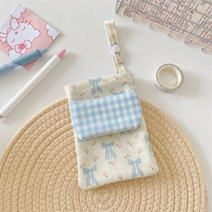 Close-up of floral nurse pocket pouch with blue ribbon pattern and checkered pocket detail