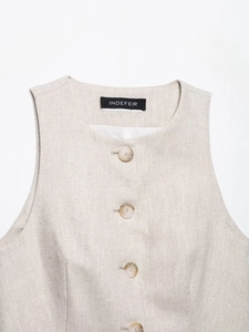 Close-up of beige woven vest featuring marble-textured buttons and premium neckline detail