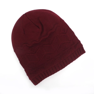 Detailed view of burgundy knit beanie featuring geometric diamond pattern and ribbed cuff