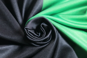 Macro trama del morbido tessuto bicolore verde e nero che mostra il drappeggio e i dettagli