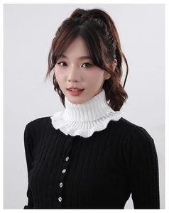 Detail of white knitted high collar with ruffle edges on a black sweater