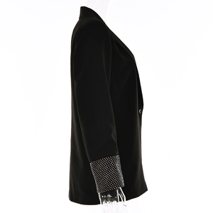 Dettaglio dei lustrini argento sulle maniche di un blazer nero da donna elegante
