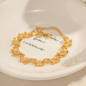 Vue détaillée du bracelet à maillons papillon dorés avec chaîne de réglage et fermoir