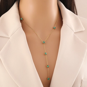 Elegant gold Y-shaped stainless steel necklace with six green glass heart pendants on model