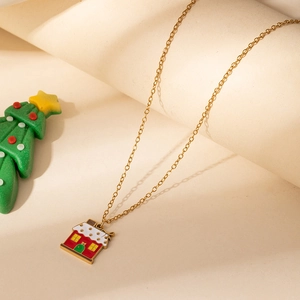 Detail of gold festive necklace featuring a colorful snowy house pendant and fine chain
