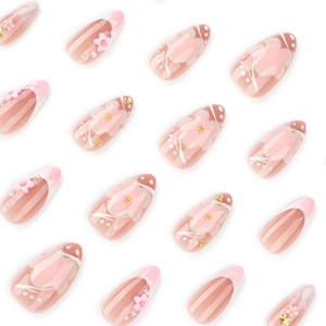 Pink almond press-on nails with 3D floral accents and pearl details on white background