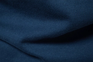 Detailed macro view of dark blue knitted cotton fabric texture and soft ribbed weave