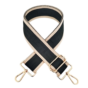 Detail of 5cm wide maze pattern strap with beige and black weaving and gold hardware