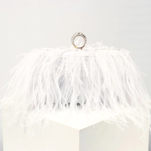 Detail of white feather evening clutch featuring a luxury diamond-encrusted ring clasp