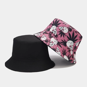 Detail of reversible bucket hats in black and purple street style skull patterns