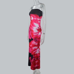 Dettaglio di un vestito lungo aderente con stampa floreale rosa vivace su tessuto nero