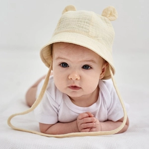 Close-up of baby sun hat featuring cute 3D ears and soft chin straps in light yellow cotton
