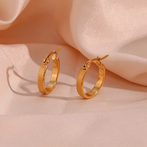 20mm gold plated stainless steel hoop earrings with diagonal stripe texture on pink silk