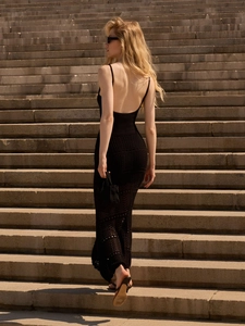 Detail of black knitted beach dress featuring backless design and crochet texture