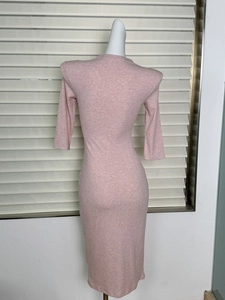 Detail of pink slim fit ribbed knit midi dress showing vertical texture and mock neck