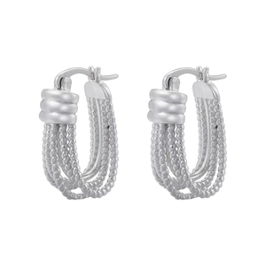 Detail of silver twisted rope U-shaped earrings with intricate woven metal texture