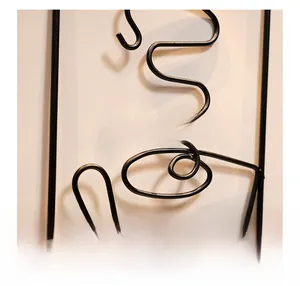 Detail of matte black metal wall art with smooth edges and subtle shadows on the wall