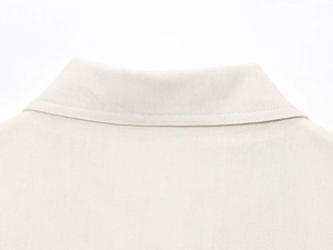 Gros plan détaillé sur les coutures du col et la texture lin d'une veste beige